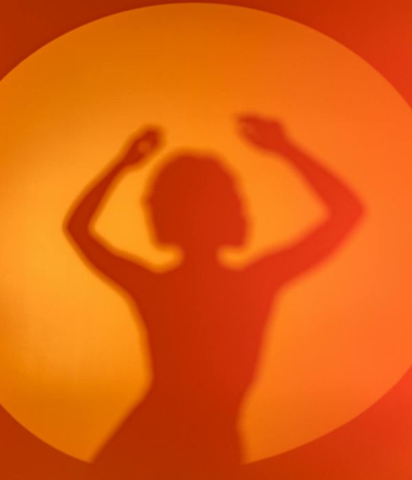 Woman performing a fluid yoga movement in a bright studio.